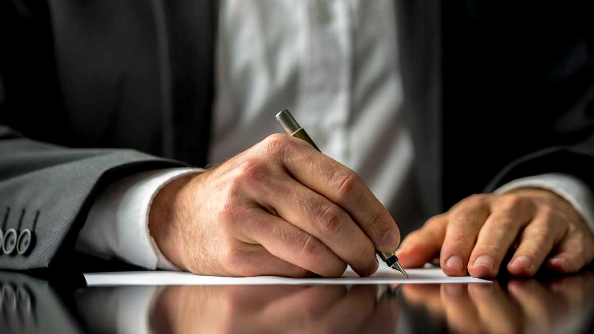 Hombre firmando documentos de herencia o venta de vivienda antes de fallecer