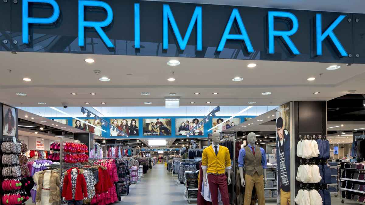 Interior de una tienda de Primark con rótulo azul y pasillos de ropa