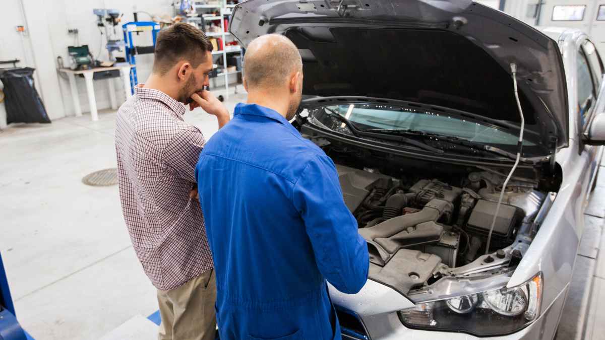Cliente y mecánico revisan motor del coche en taller tras presupuesto de 11.000 euros