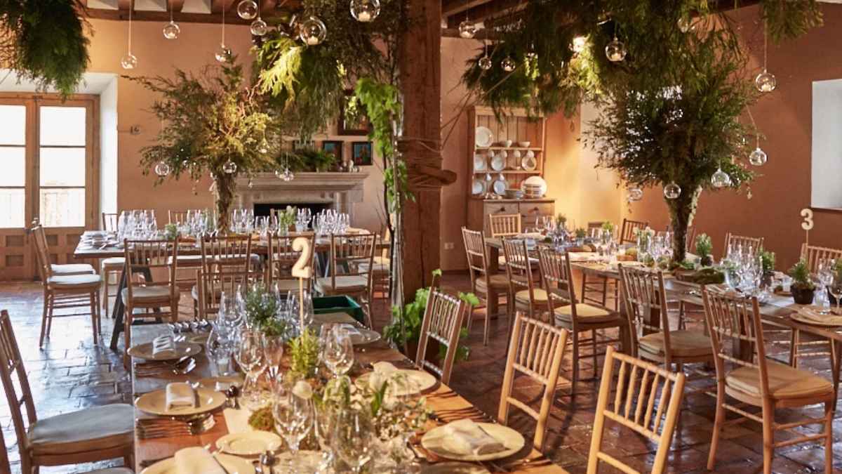 Interior restaurante Samantha Vallejo-Nágera Casa Taberna en Pedraza con mesas de madera, copas y decoración vegetal colgante