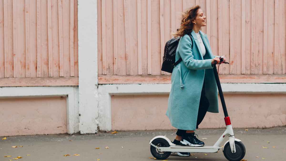 Mujer en patinete eléctrico por la ciudad; desde enero el seguro será obligatorio para VMP