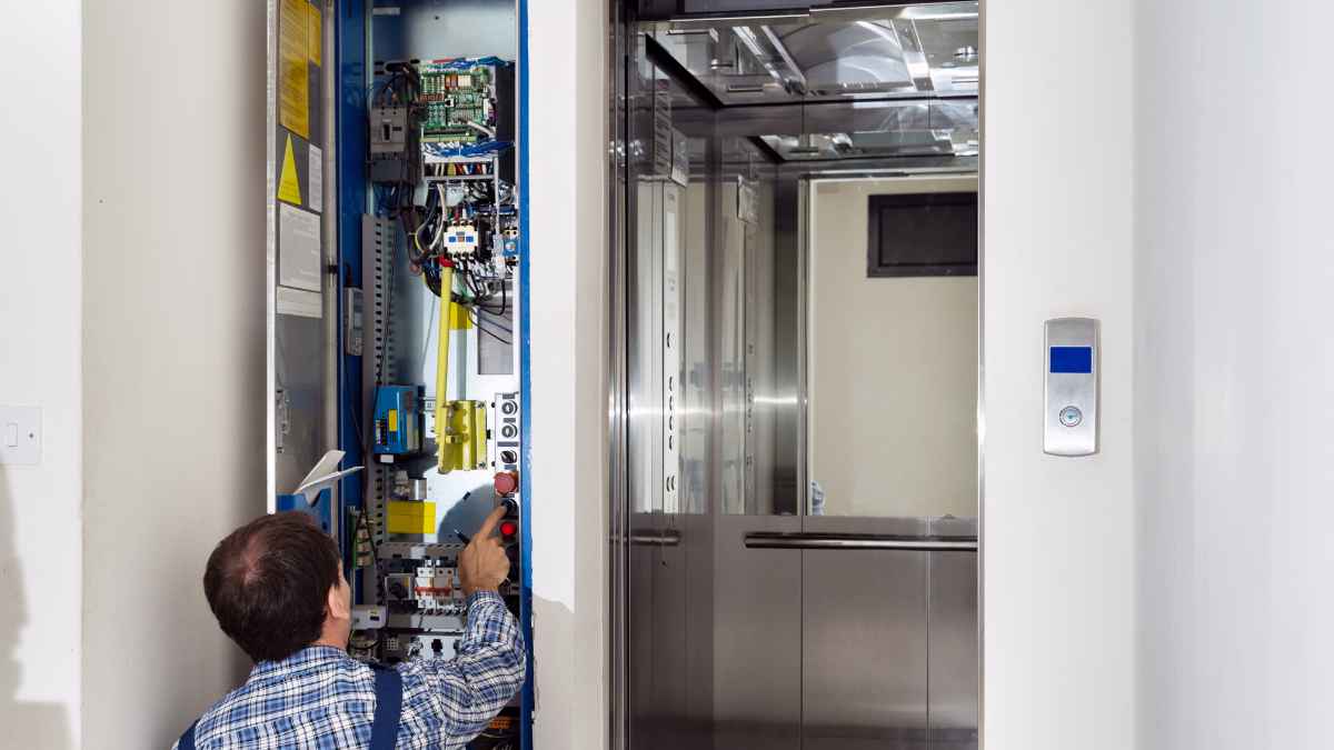 Técnico instalando y revisando un ascensor en un edificio residencial para mejorar la accesibilidad