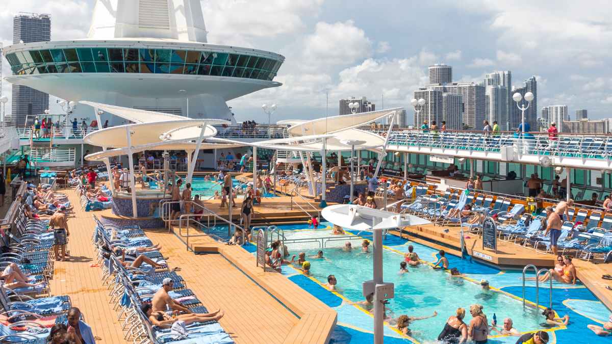Cubierta de un crucero con piscinas y numerosos pasajeros; contexto del reportaje sobre trabajo en cruceros.