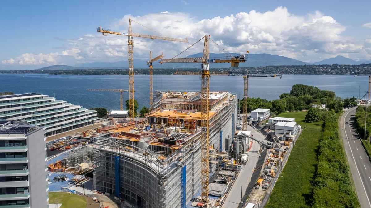 Obra de construcción en Suiza con grúas y edificios junto al lago