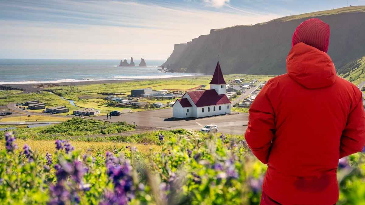 Iglesia de tejado rojo en Vik Islandia con vistas al mar y montañas