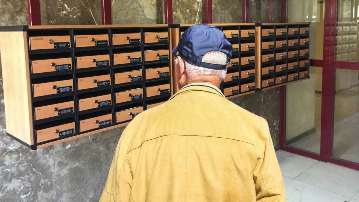 Jubilado revisando el buzón a la espera de la carta del IMSERSO en septiembre