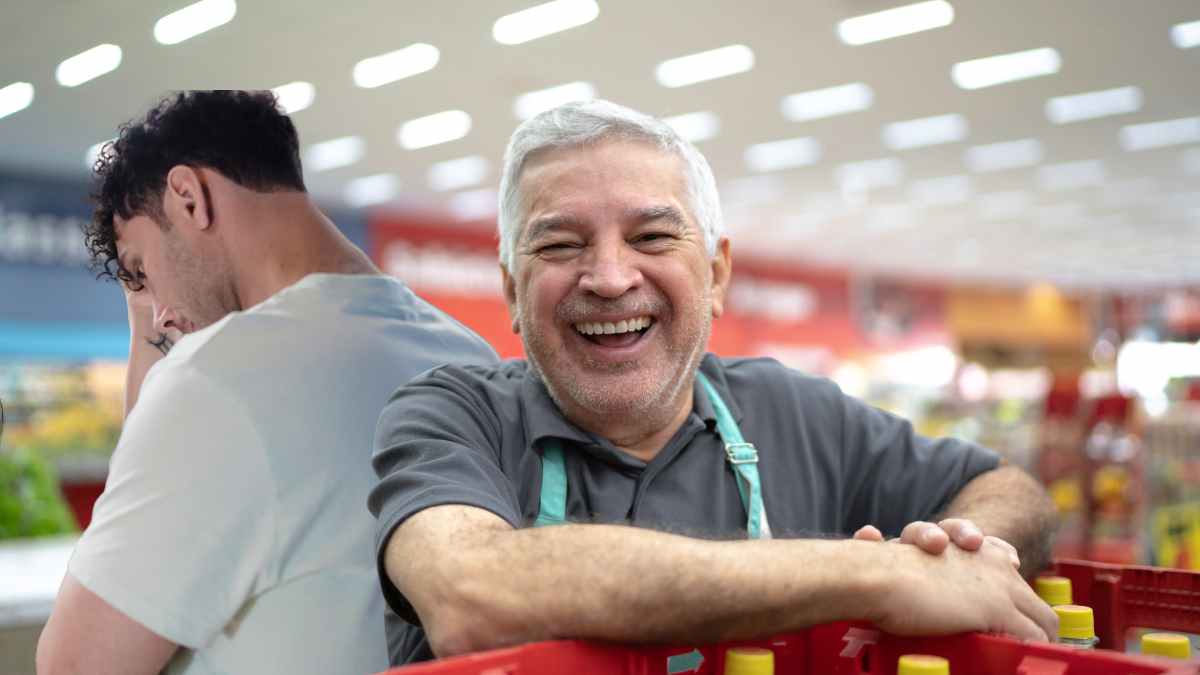 Trabajador mayor de 70 años en supermercado junto a compañero más joven