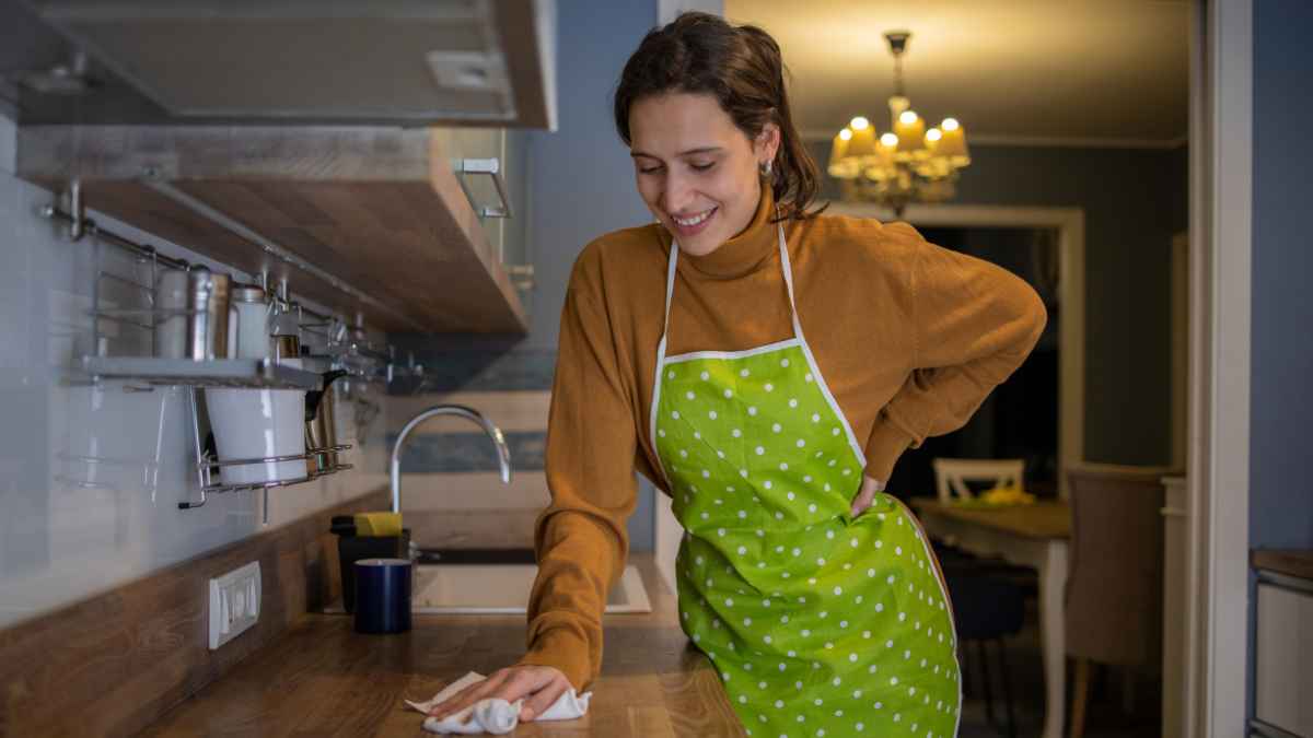 Empleada del hogar limpiando la cocina, concepto de sanciones por contratación ilegal