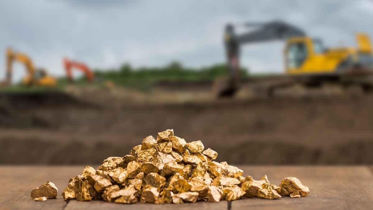 Lingotes de oro extraídos en mina con maquinaria al fondo en Hunan, China