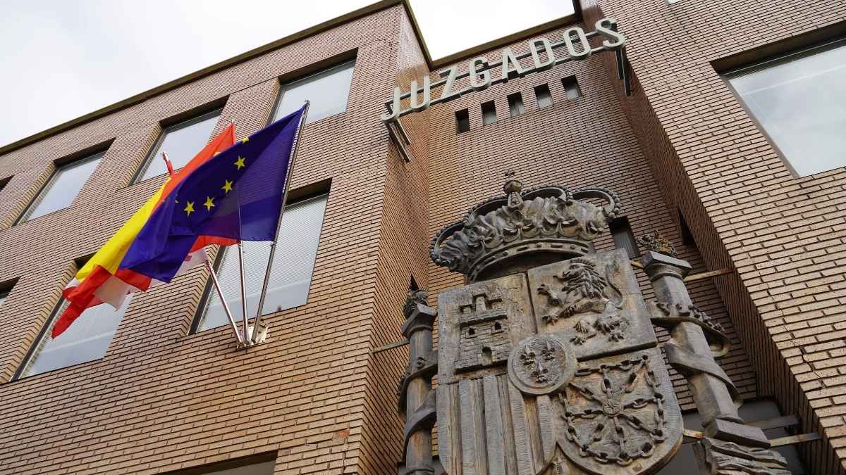Fachada de juzgados en España con escudo y banderas en un caso de despido inventado para cobrar el paro