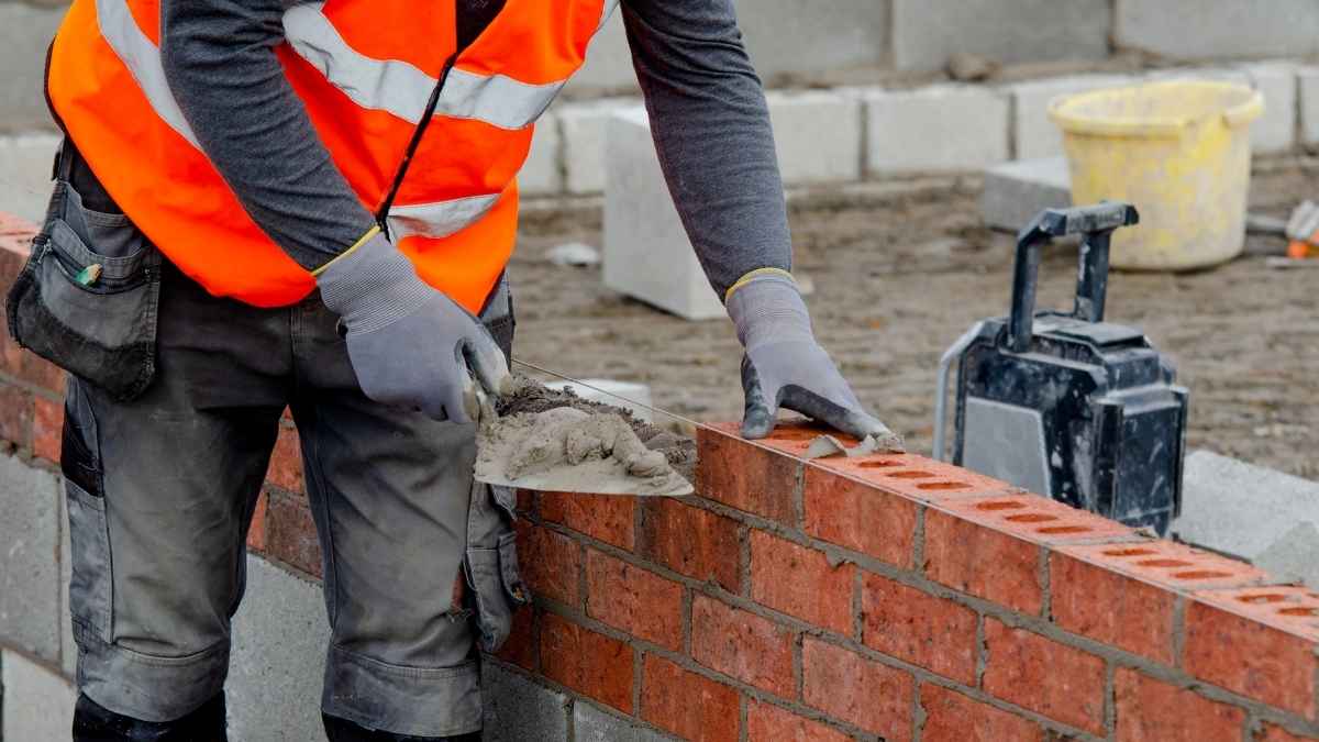 Obrero de 57 años levantando muro de ladrillo en la construcción ante la falta de relevo generacional