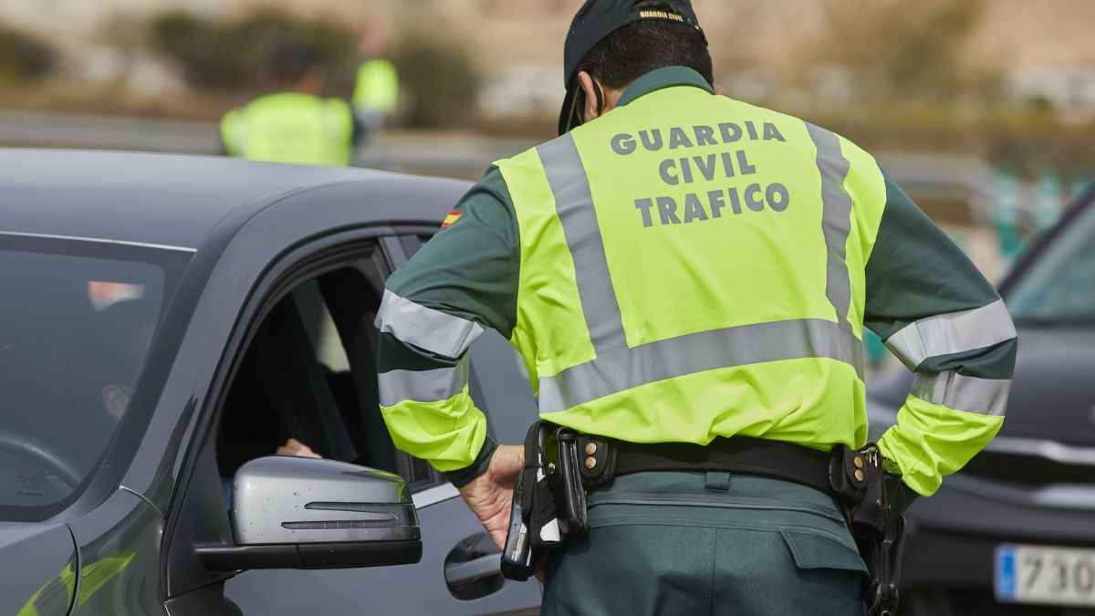 Agente de la Guardia Civil de Tráfico multa a un conductor por uso indebido del móvil en el coche