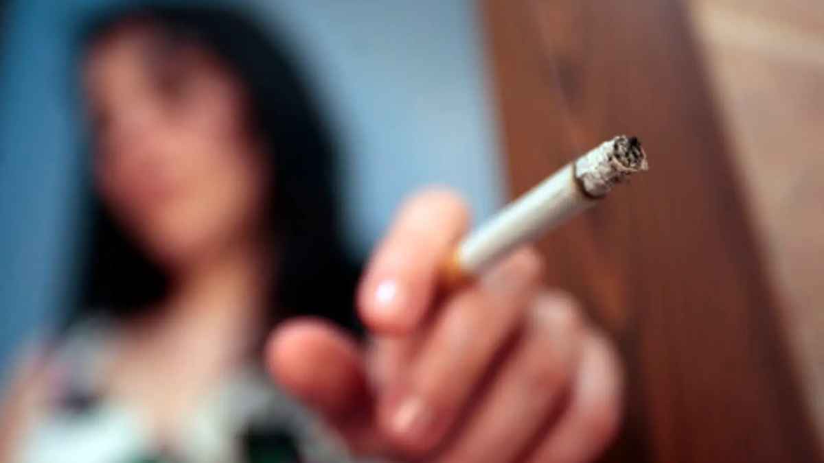 Adolescente con cigarrillo encendido en la mano, imagen sobre la ley antitabaco que multa a los padres.