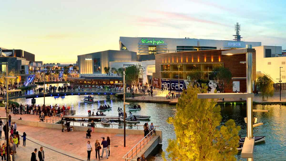 Centro Comercial Puerto Venecia en Zaragoza al atardecer con visitantes y actividades en el lago