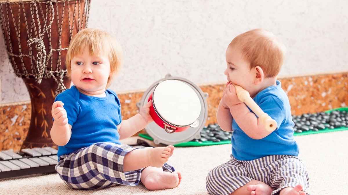 Dos bebés jugando en casa vinculados a la prestación por nacimiento y cuidado de menor