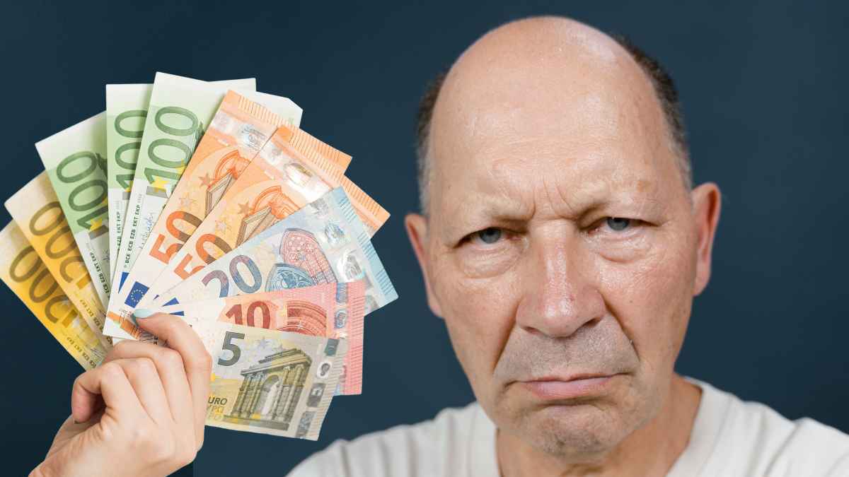 Hombre preocupado con billetes de euro en la mano relacionado con subsidios del SEPE