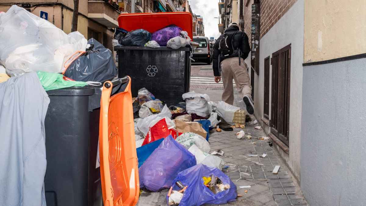 Contenedores de basura llenos en una calle de Madrid afectados por la nueva tasa de basuras