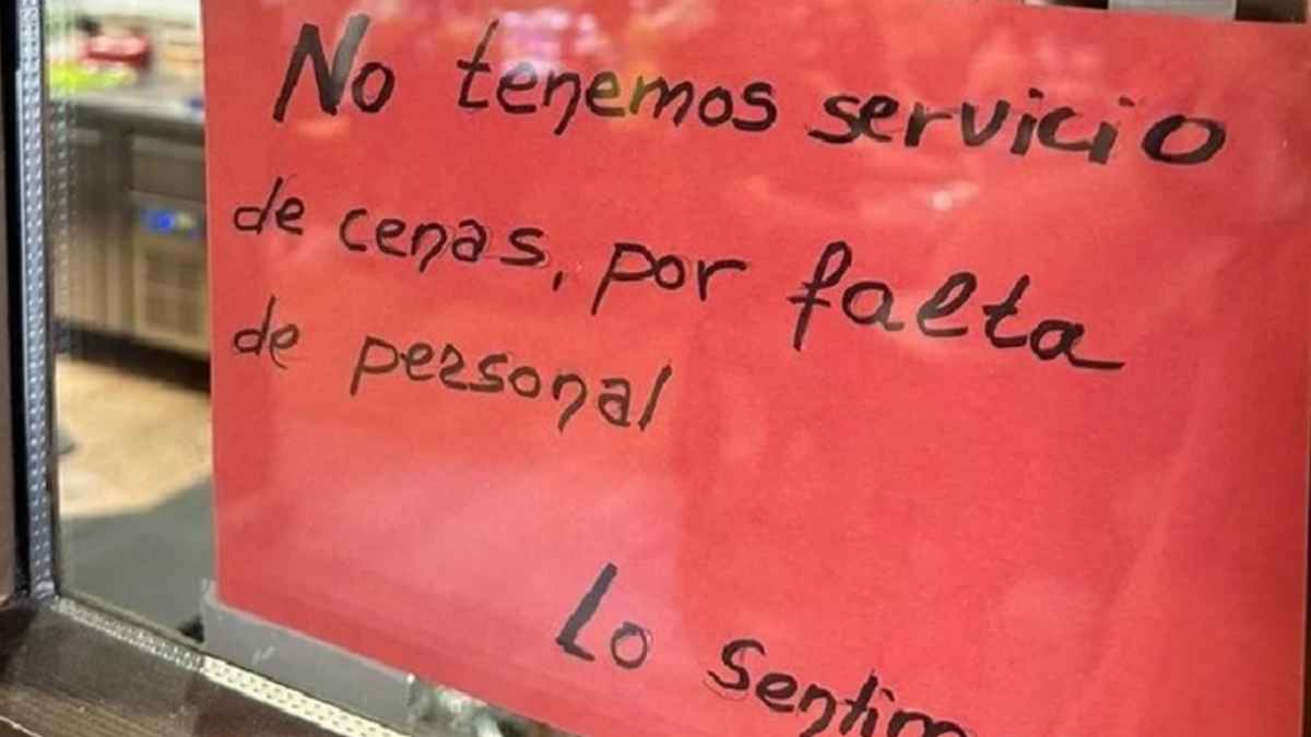 Cartel en la puerta de un bar que anuncia el cierre del servicio de cenas por falta de personal en la hostelería.