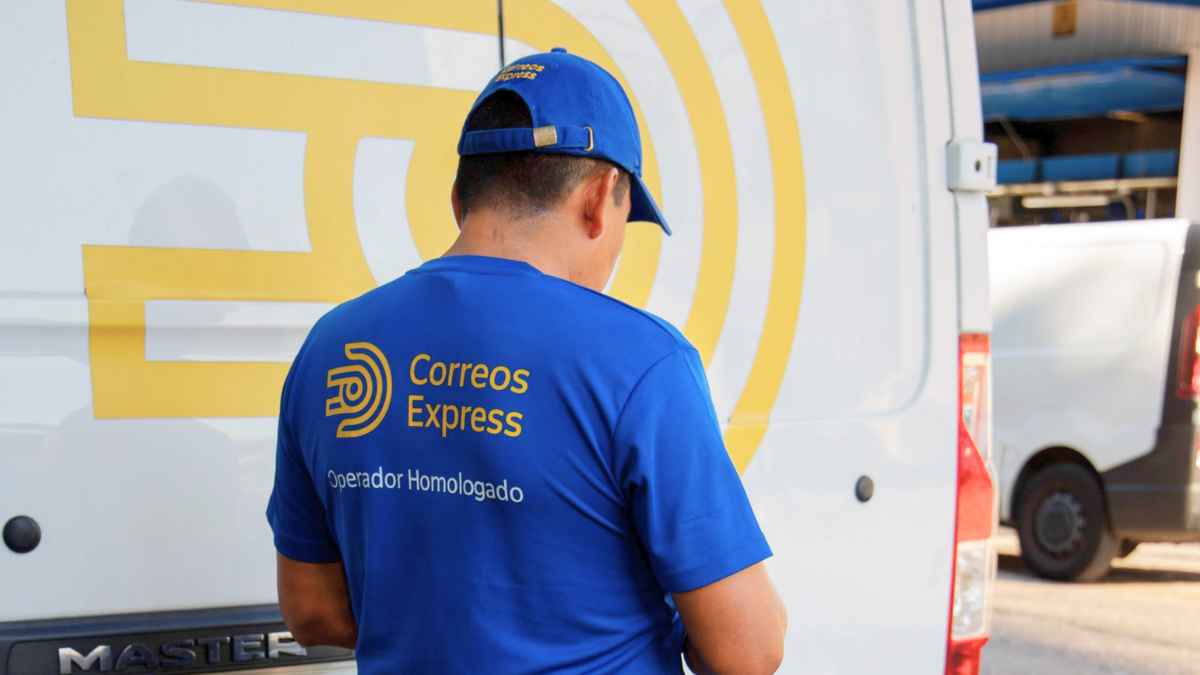 Empleado de Correos Express junto a furgoneta de reparto durante jornada laboral, ofertas de empleo fijo sin oposición.