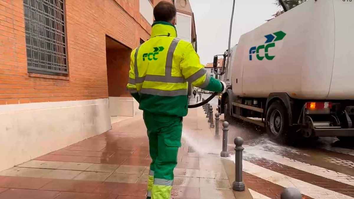 Trabajador de FCC limpiando calles con camión de servicios en España
