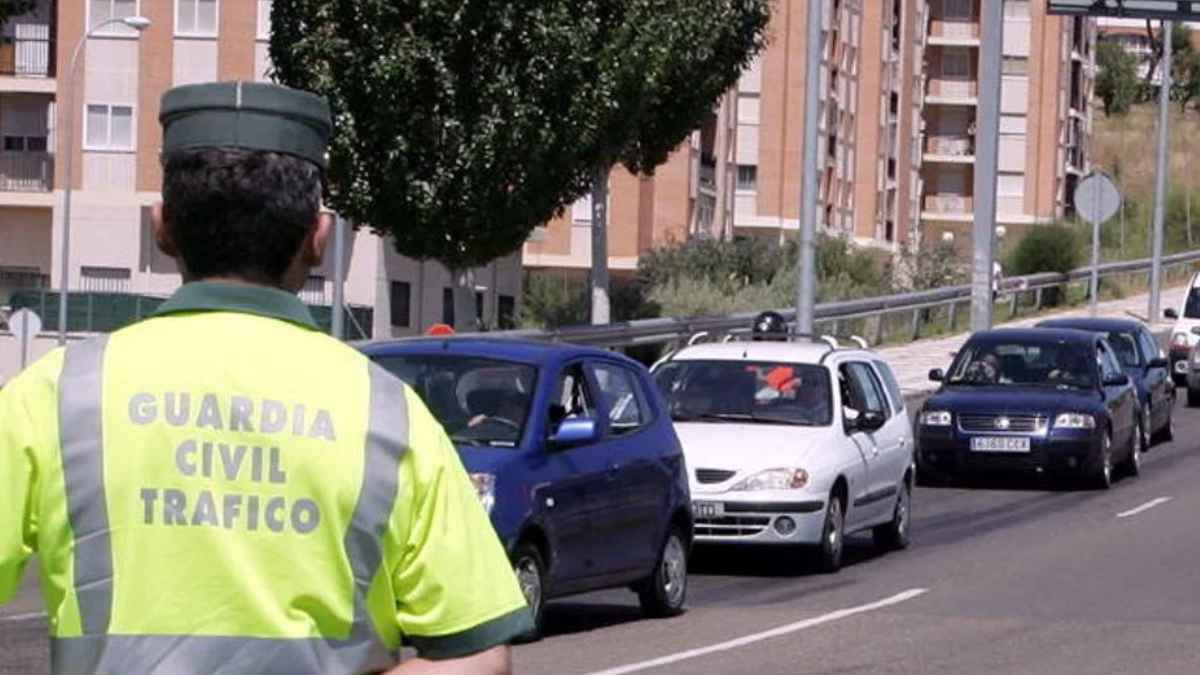 Agente de la Guardia Civil de Tráfico controlando vehículos en una ciudad con policía local