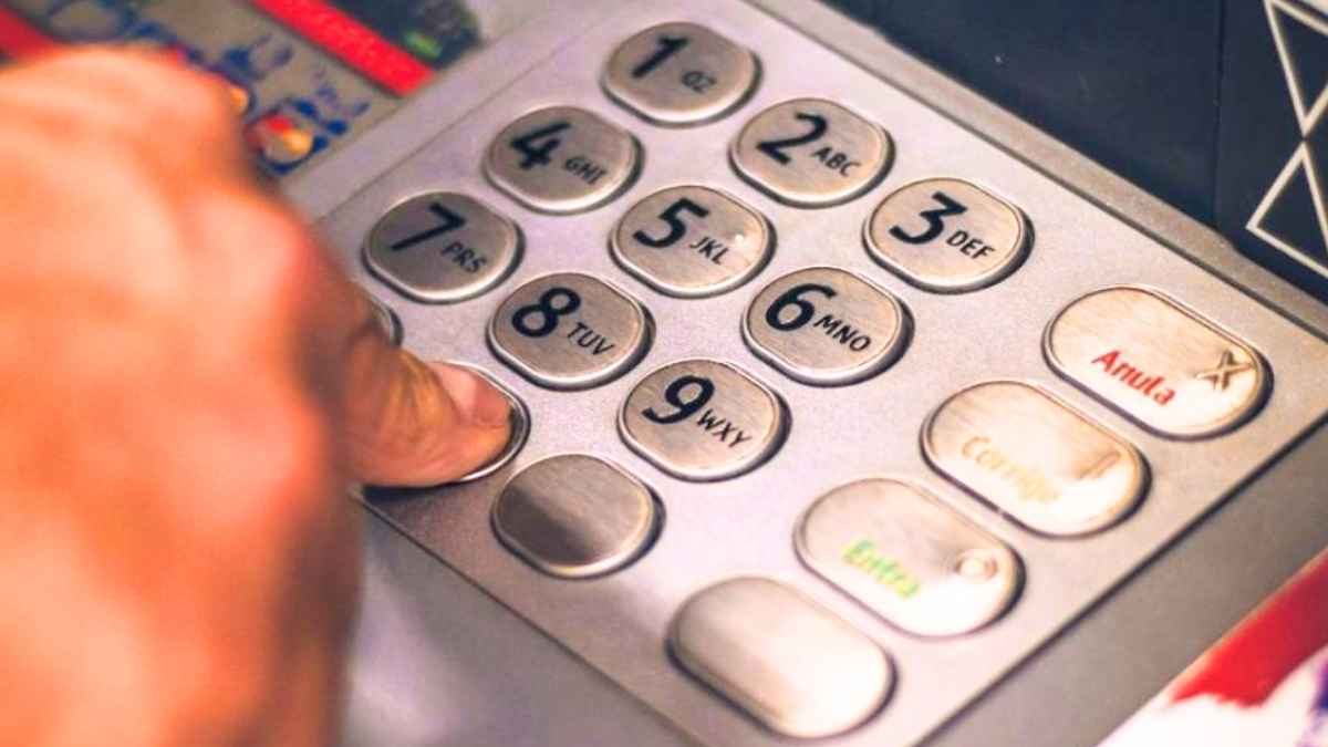 Persona utilizando cajero automático relacionado con cuentas conjuntas y declaración de la renta