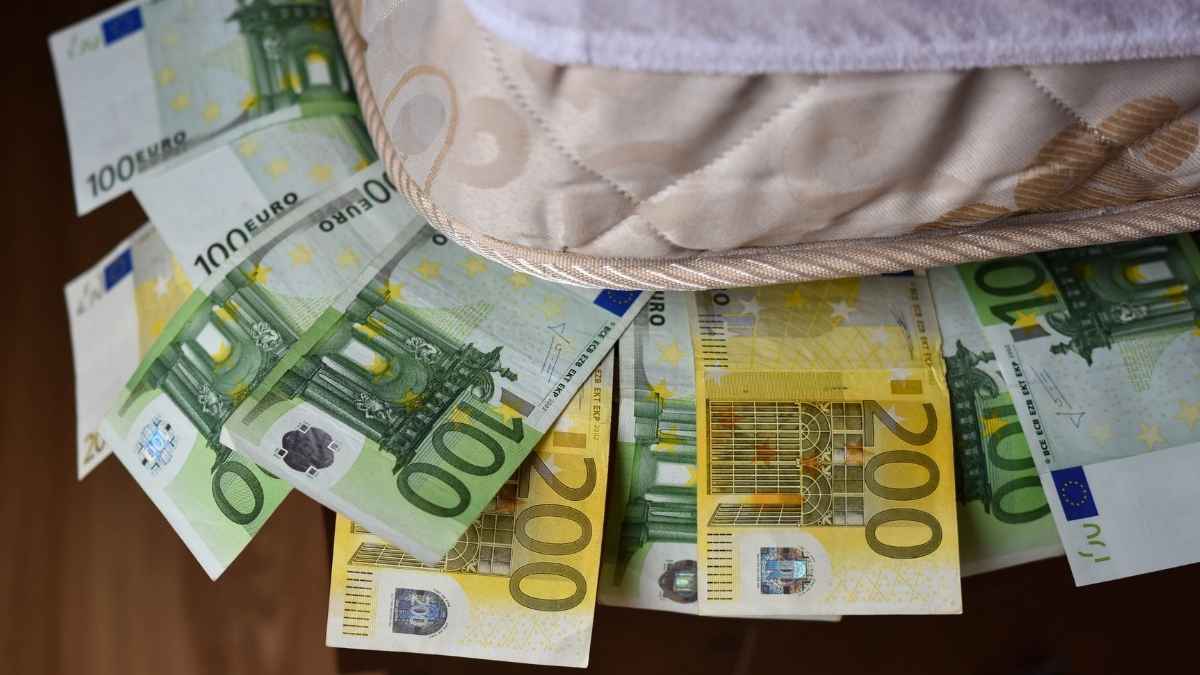 Billetes de euro guardados bajo un colchón, ejemplo de dinero en efectivo en casa que Hacienda puede considerar ingreso oculto