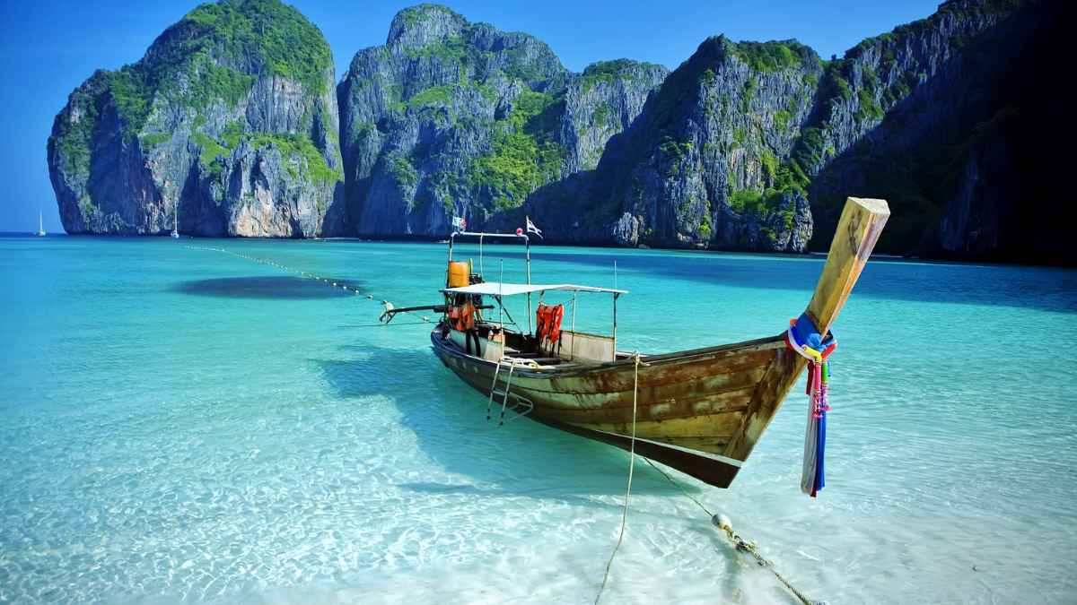 Barco tradicional tailandés en una playa tropical, destino al que se mudó un jubilado español desde Mallorca buscando una vida más barata.