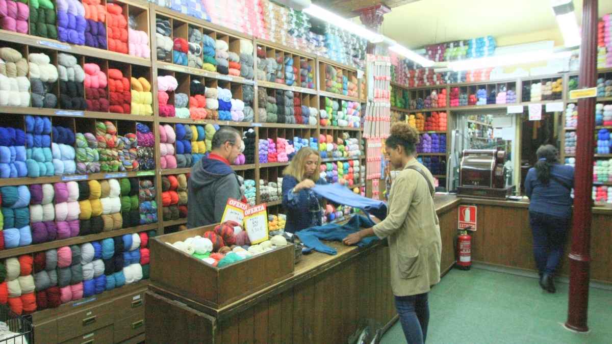 Interior de la tienda de lanas Lanas Sixto en Atocha con clientes comprando ovillos durante la liquidación por cierre.