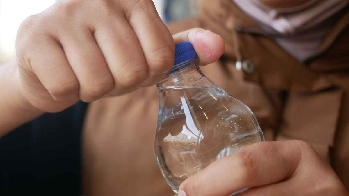 Persona abriendo una botella de agua mineral representando el análisis de la OCU sobre aguas embotelladas y su relación calidad-precio