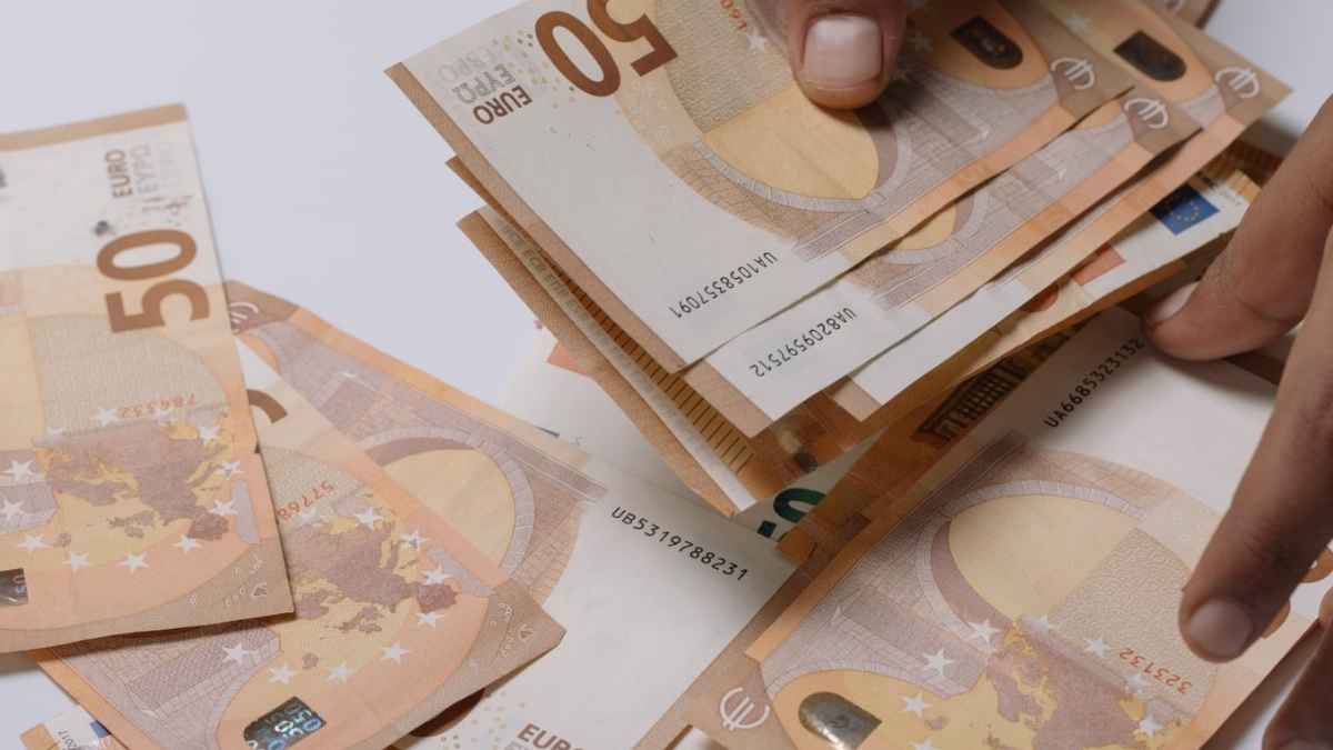 Persona contando billetes de 50 euros representando el cobro de la prestación por nacimiento del SEPE