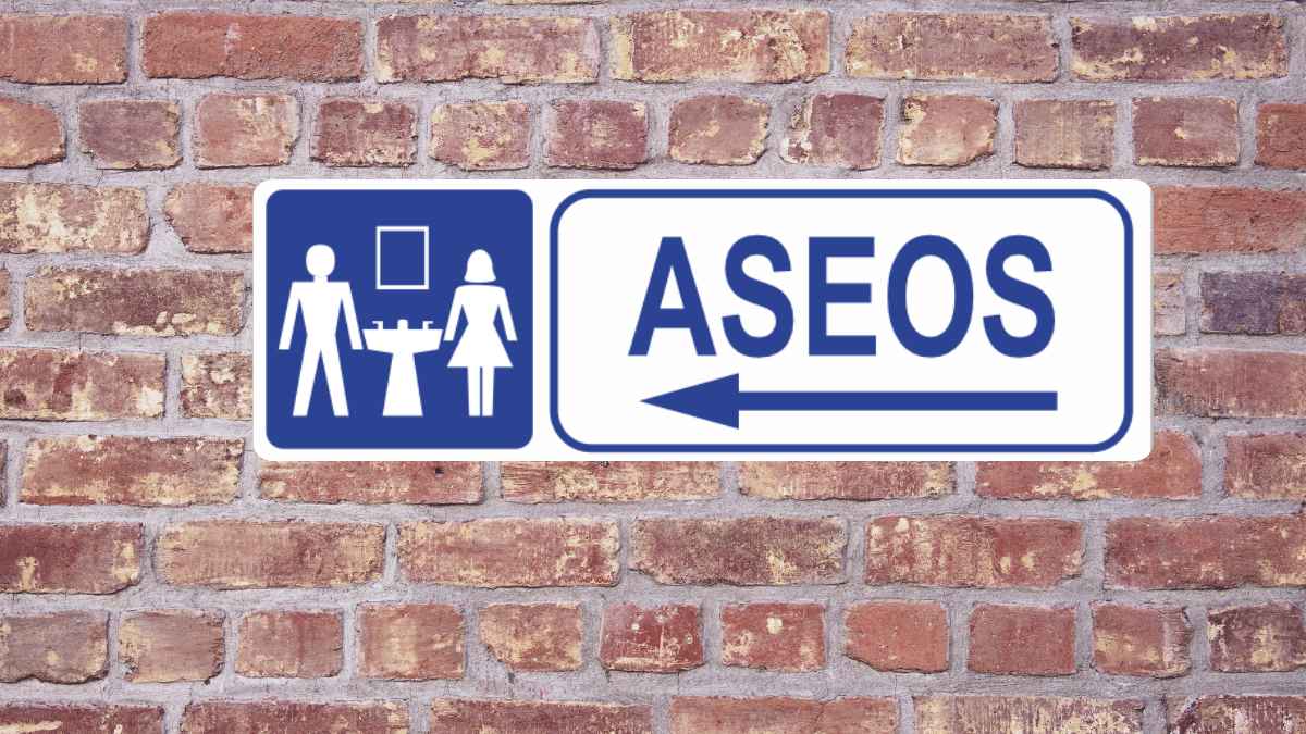 Cartel de aseos en una pared de ladrillo relacionado con la polémica de una panadería de Barcelona