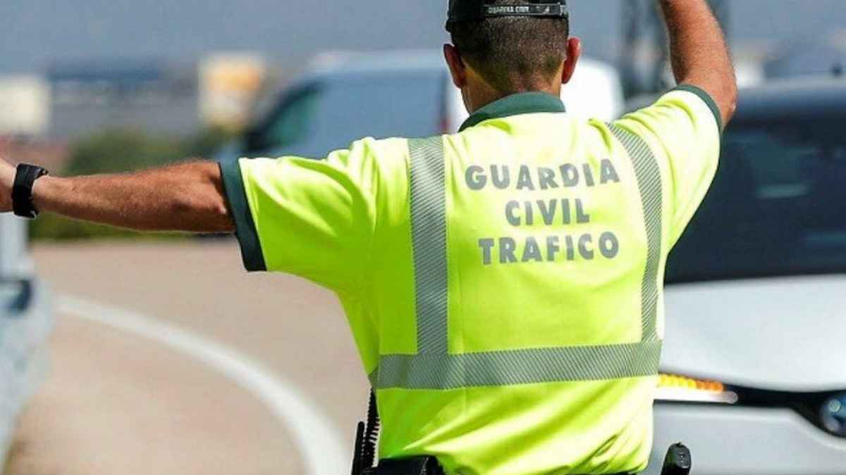 Agente de la Guardia Civil de Tráfico deteniendo vehículos en carretera para control de multas de la DGT