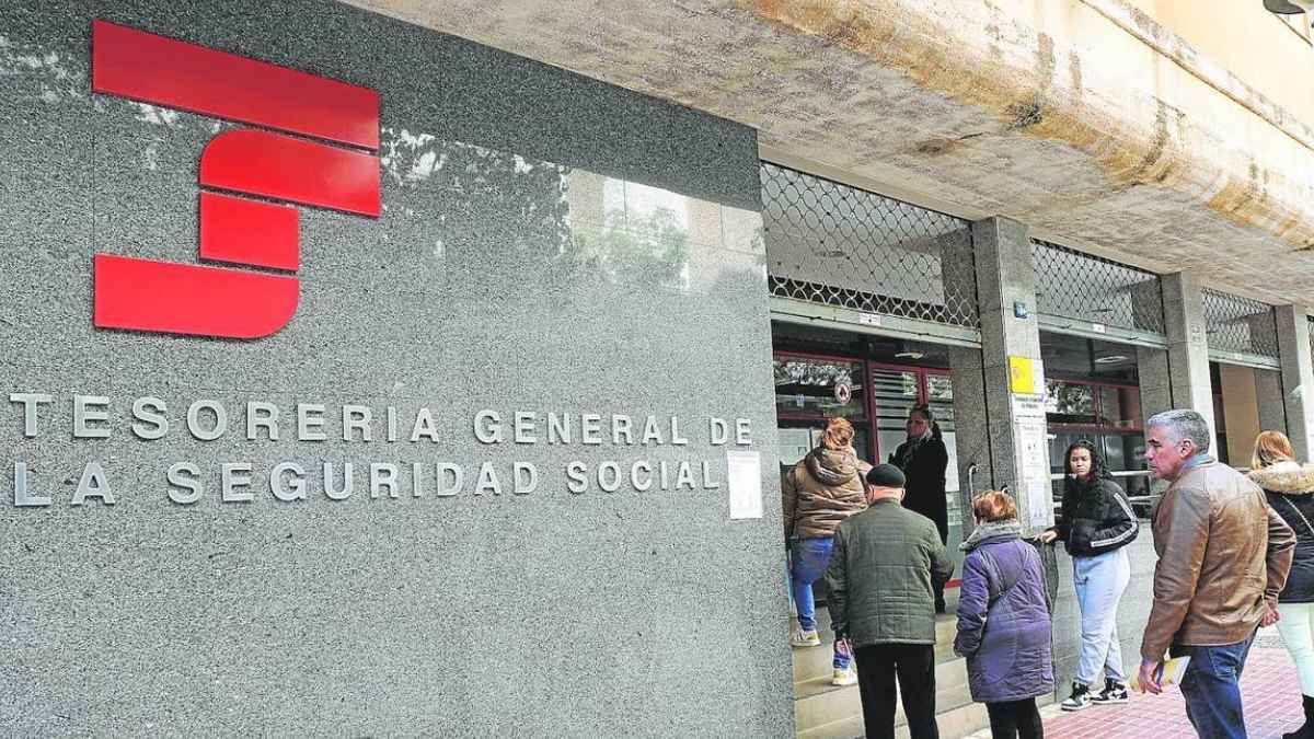 Personas frente a una oficina de la Tesorería General de la Seguridad Social en España, relacionada con los nuevos requisitos de jubilación a los 65 años en 2026.