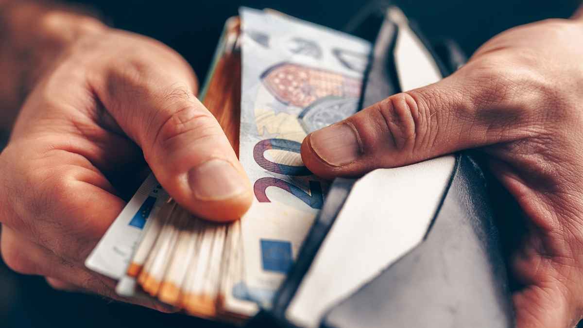 Persona sosteniendo billetes de euro representando el subsidio especial del SEPE de 600 euros en 2025
