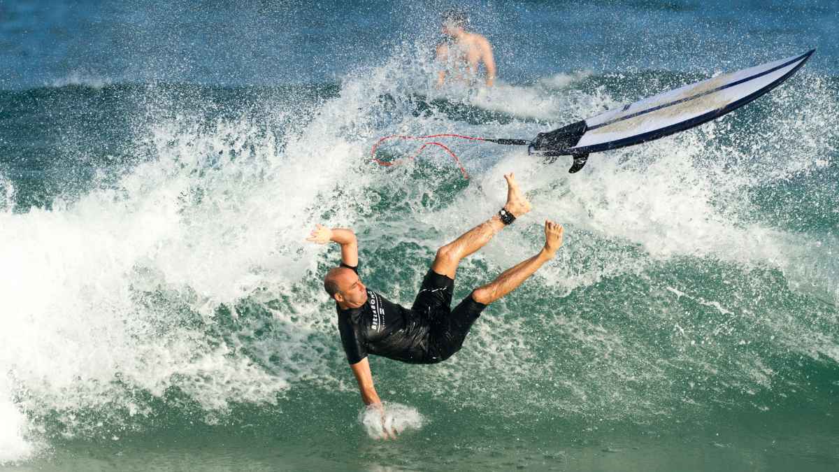 Hombre cayendo al agua con una tabla de surf, imagen ilustrativa del caso de despido en Decathlon por regalar una tabla.