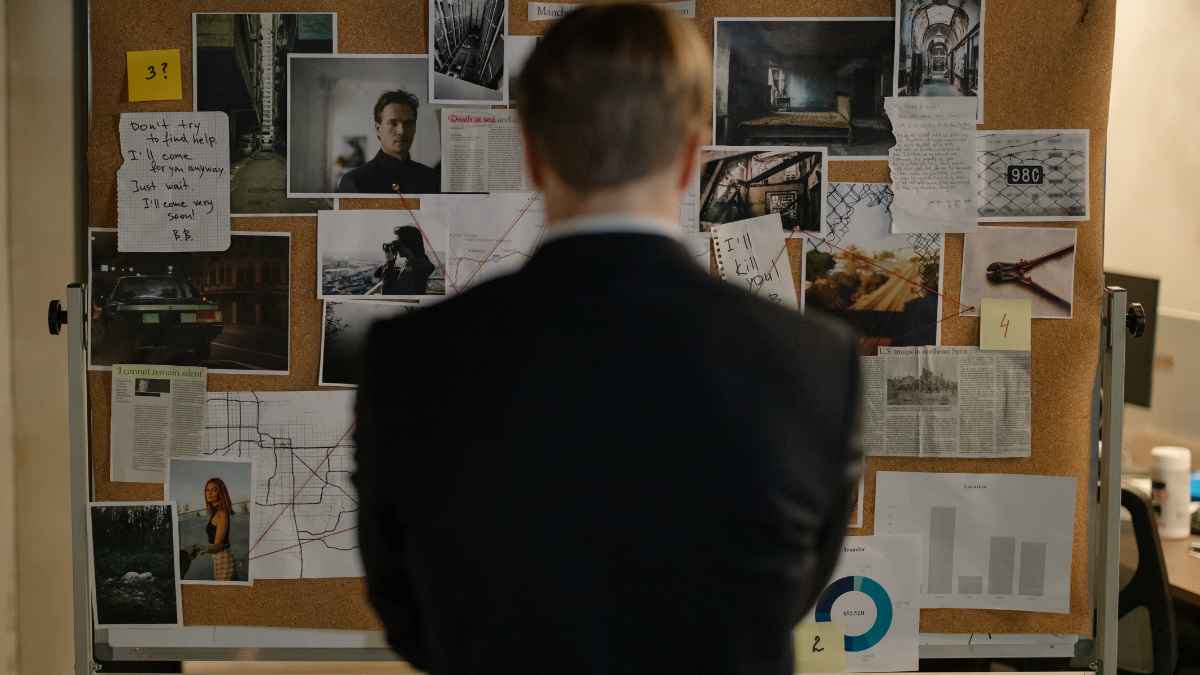 Detective analiza pruebas en un tablero de investigación en un caso laboral de despido improcedente