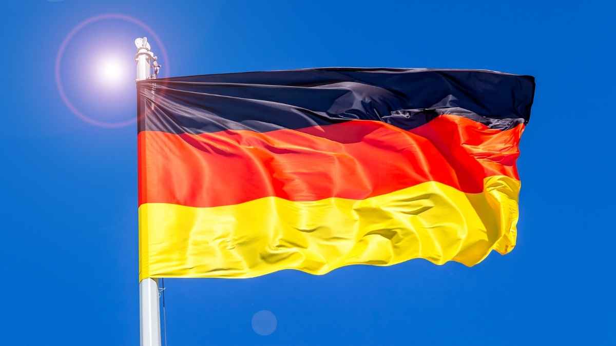 Bandera de Alemania ondeando al sol, ilustrando oferta de empleo para españoles con contrato fijo y jornada completa