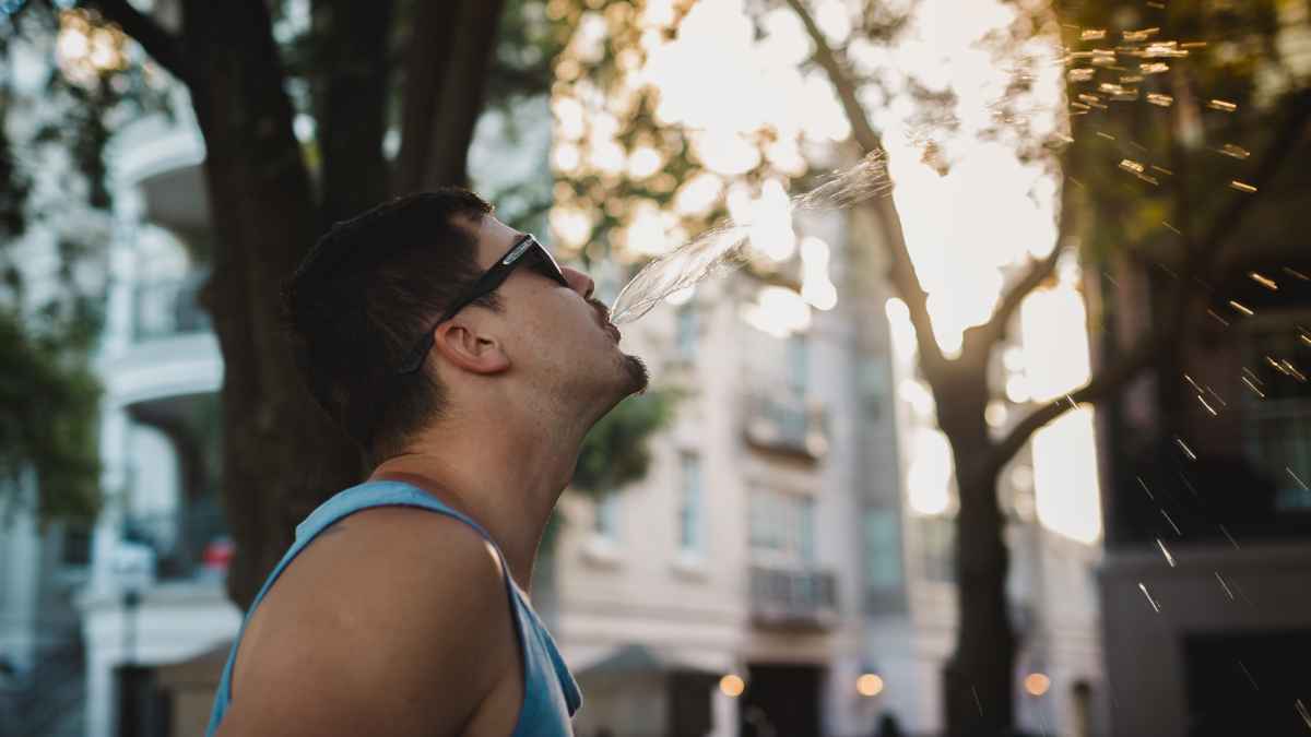Hombre escupiendo en la calle en un entorno urbano al aire libre