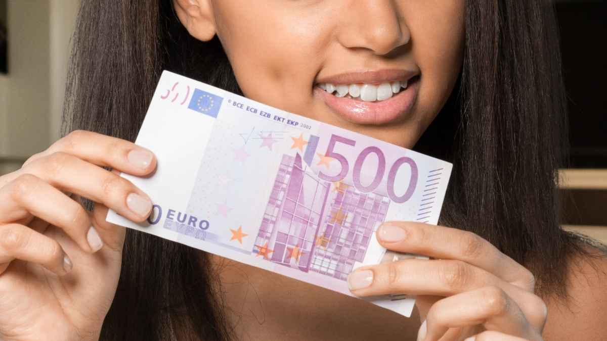 Mujer sosteniendo un billete de 500 euros como representación de la promoción bancaria que ofrece hasta esa cantidad.