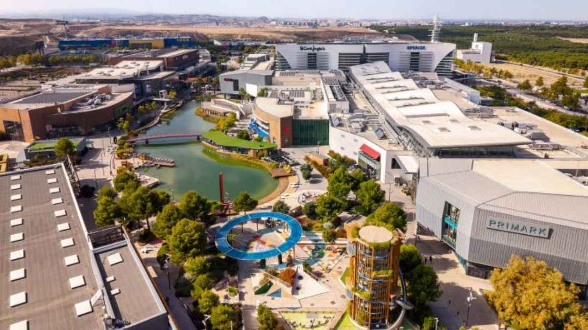 Vista aérea del centro comercial Puerto Venecia en Zaragoza, con zonas comerciales, lago y áreas de ocio.
