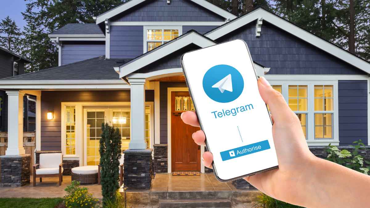 Mano sosteniendo un móvil con Telegram frente a una vivienda, ejemplo de compra de casas sin verlas a través de la aplicación.