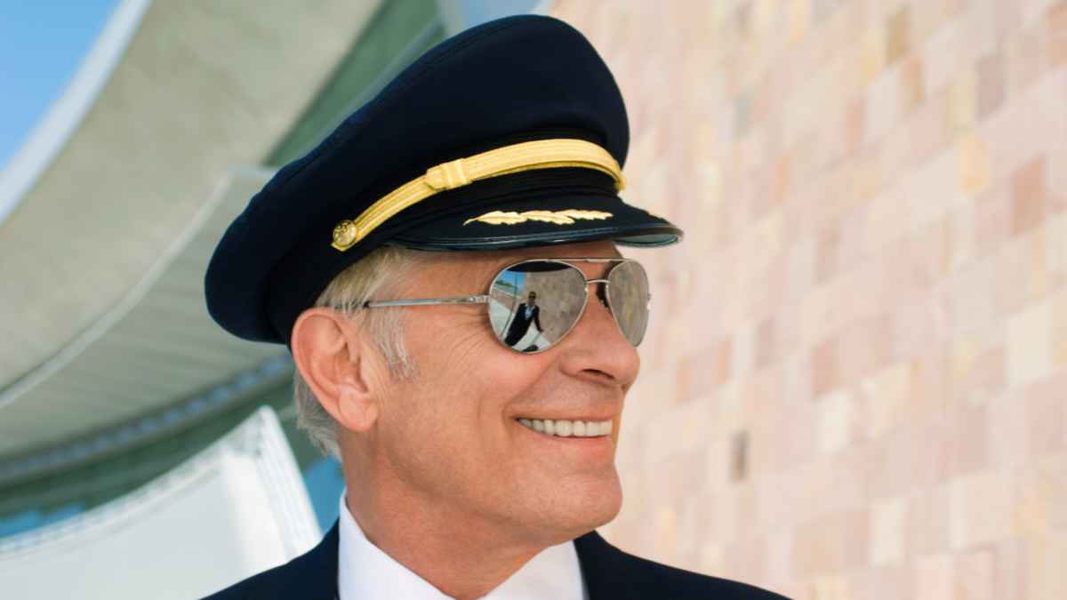 Hombre vestido de piloto de avión con gorra y gafas de sol, imagen ilustrativa del caso del falso piloto que estafó a unos caseros en París.