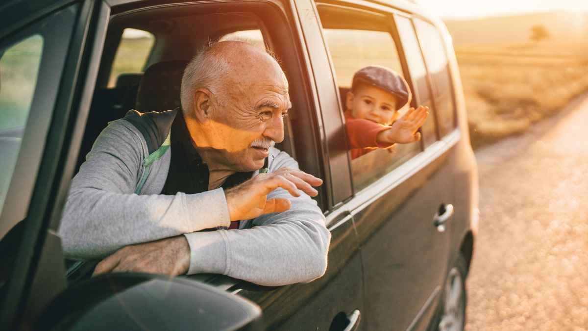 Hombre mayor conduciendo con un niño mientras la DGT estudia endurecer los test del carnet de conducir desde los 65 años