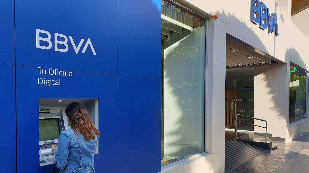 Persona utilizando un cajero automático de una oficina de BBVA en el exterior.