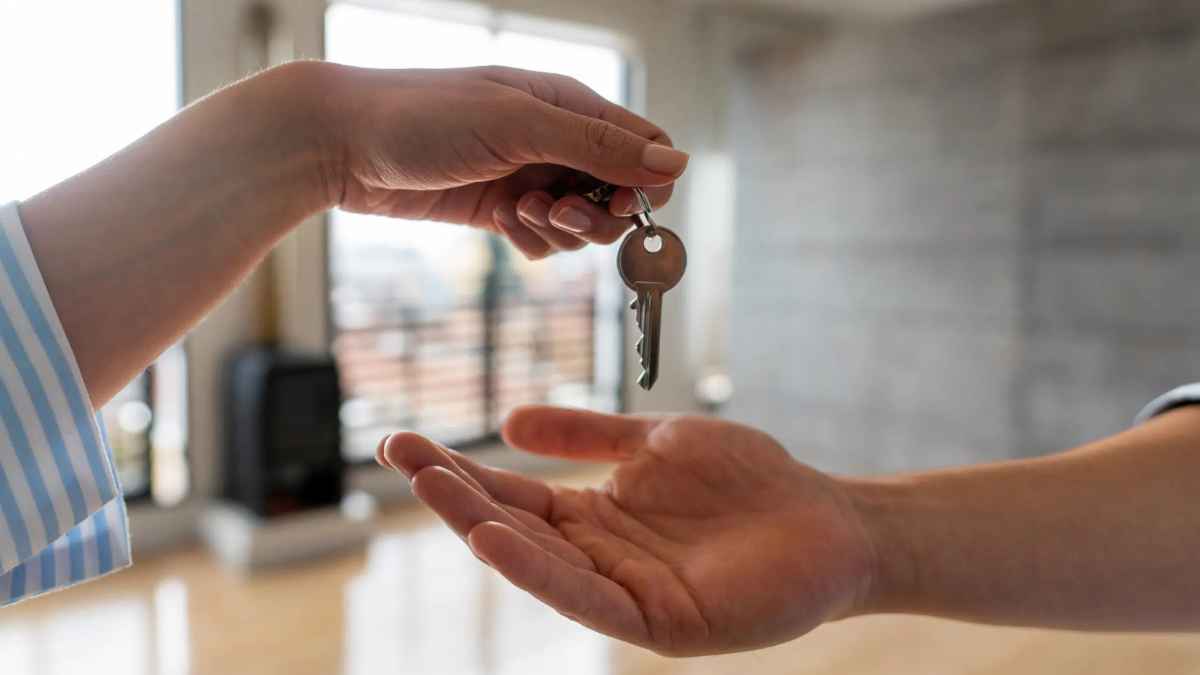 Entrega de llaves de una vivienda entre dos personas en el interior de una casa