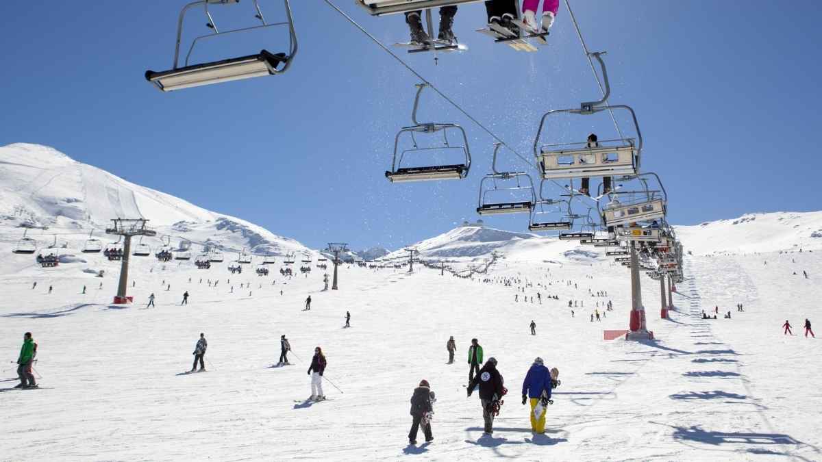Esquiadores en una estación de esquí con telesillas en funcionamiento durante la temporada de invierno