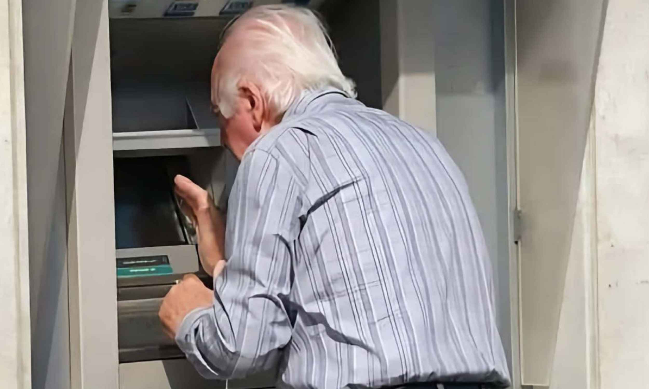 Hombre mayor consultando su cuenta en un cajero automático para comprobar el cobro del paro de noviembre de 2025
