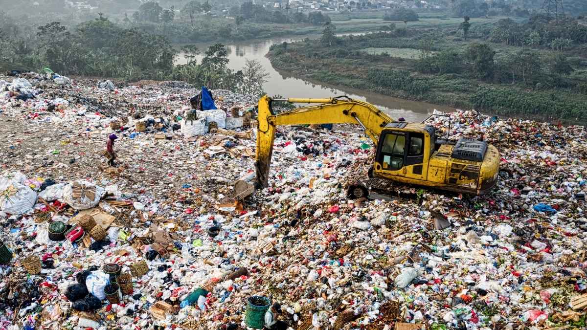 Excavadora removiendo basura en un vertedero similar al lugar donde el informático James Howells busca su disco duro con 8.000 bitcoins perdidos