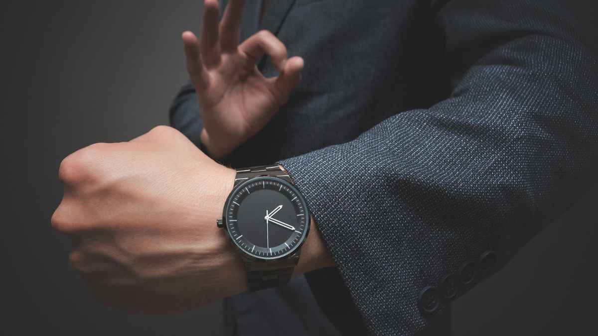 Hombre revisando la hora en su reloj de pulsera en un contexto laboral